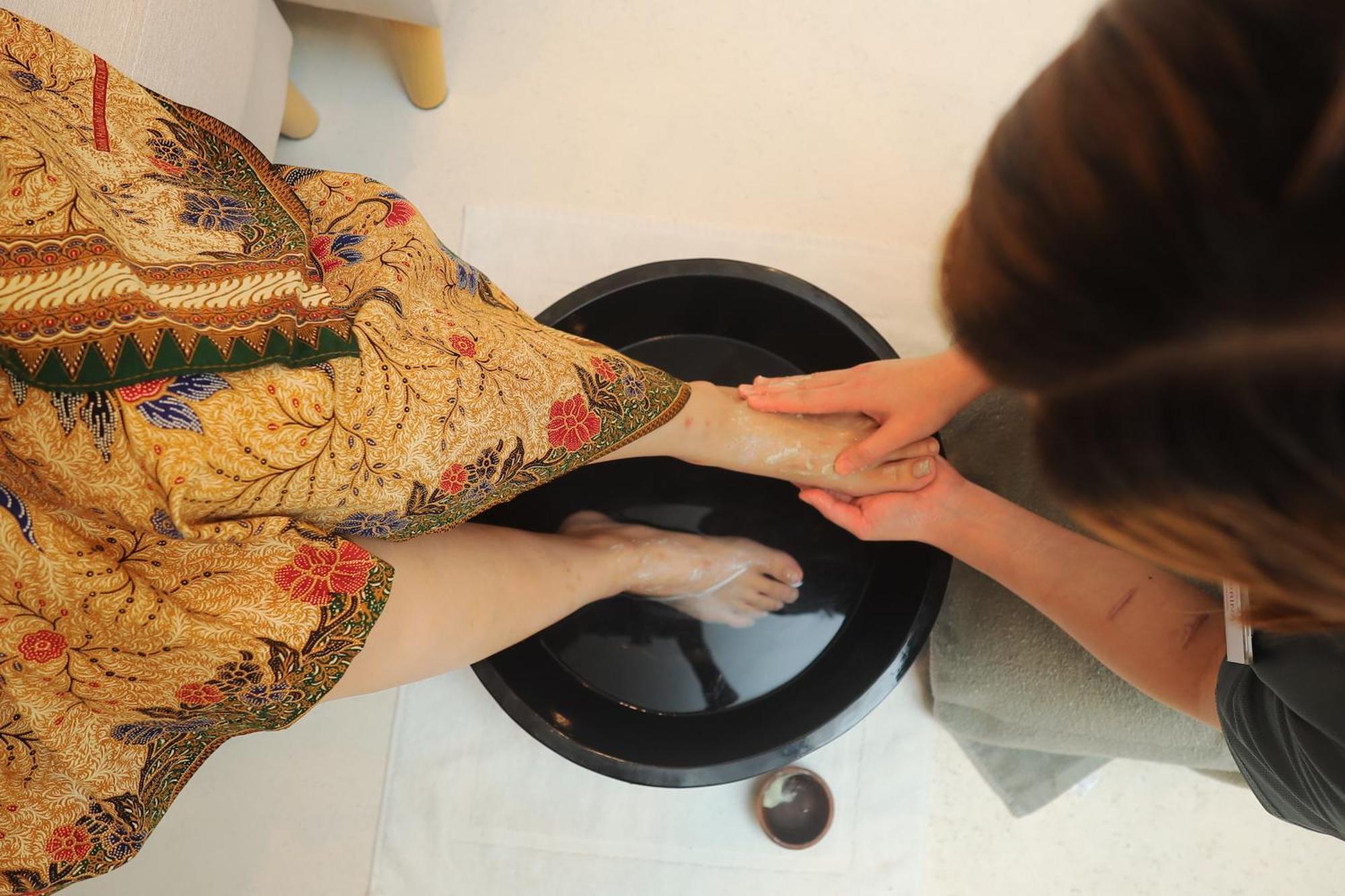 The Riyaz Lavanya Langkawi Pantai Cenang  Bagian luar foto A woman washing the feet of a guest